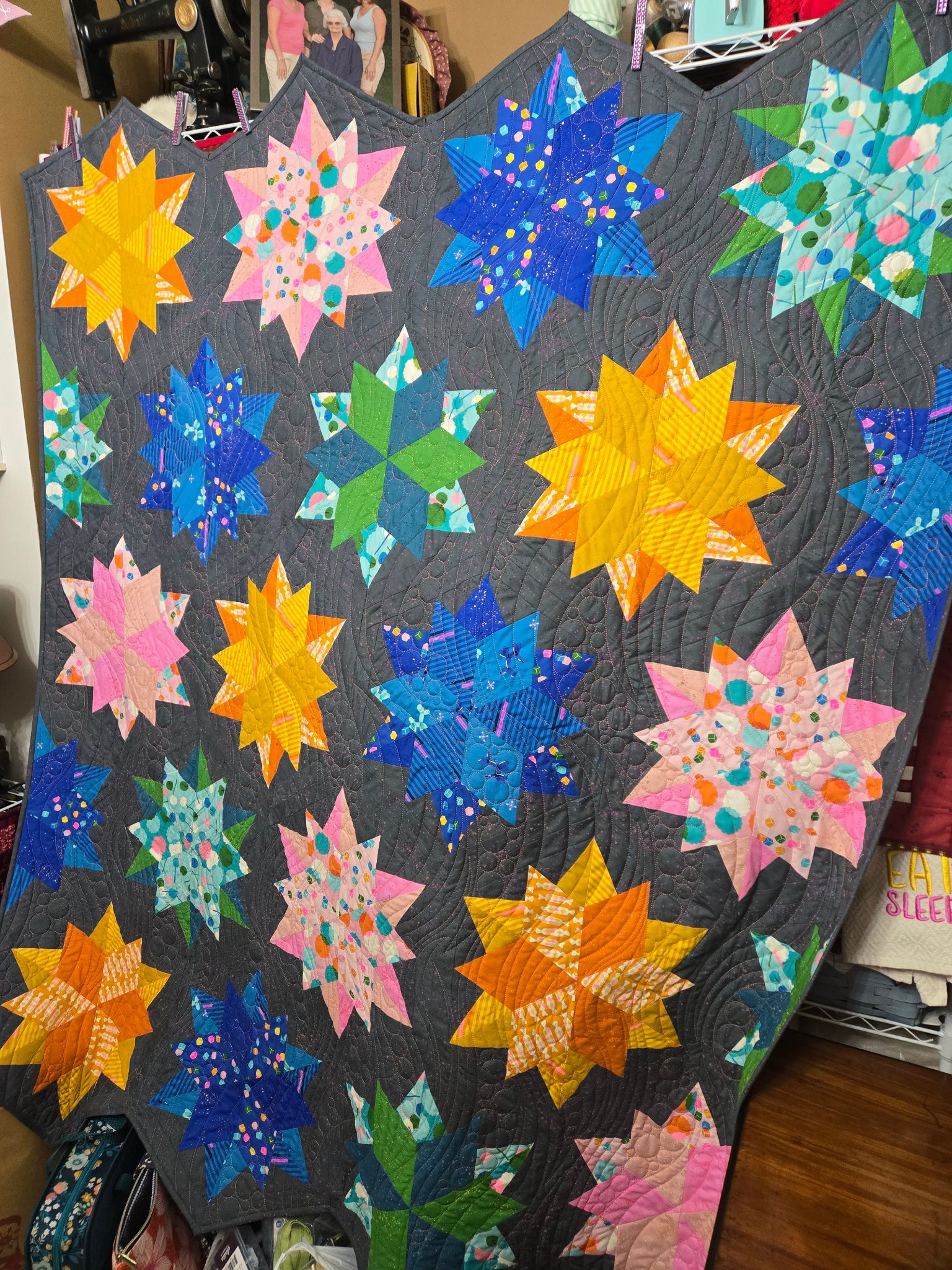 Colorful star quilt on dark background — Night Sky quilt finished on the longarm